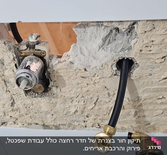 צינור שחור עם מחבר פליז בקיר חשוף